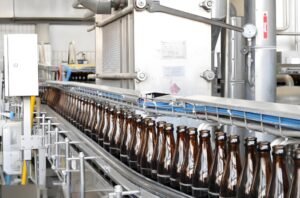 Bottles being filled with beverage products in a high-speed production line.