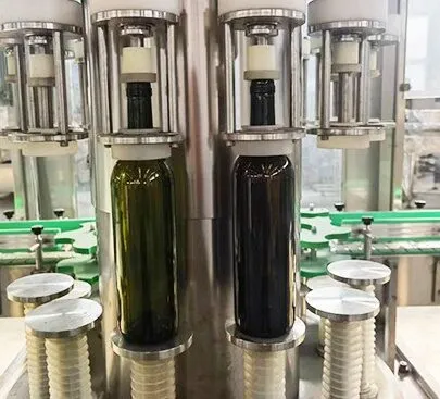 Glass bottles being filled with liquid on industrial filling line