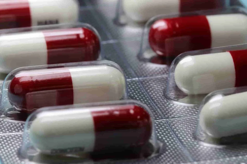 Red and white pharmaceutical capsules in blister packaging, ready for distribution