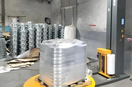 Palletizing machine stacking products on a rotating platform in an industrial setting