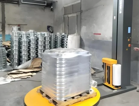 Palletizing machine stacking products on a rotating platform in an industrial setting