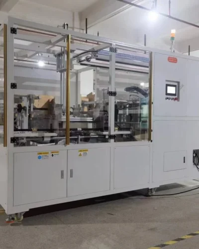 Paper Box Packaging Machine: automated system with safety enclosure and control panel.