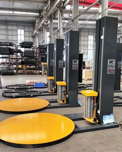 Packaging machinery: Pallet wrapping machines lined up in a factory setting.