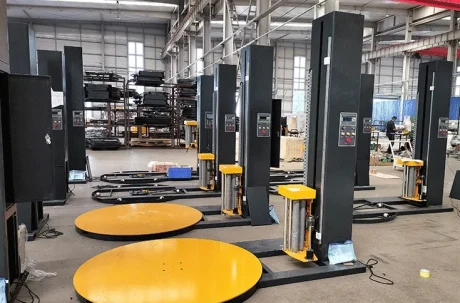 Packaging machinery: Pallet wrapping machines lined up in a factory setting.