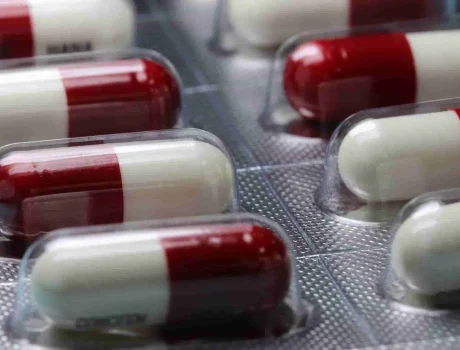 Red and white pharmaceutical capsules in blister packaging, ready for distribution