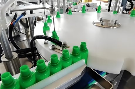 Automatic bottle filling machine handling plastic containers