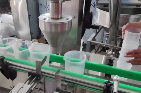 Powder filling machine dispensing product into plastic containers