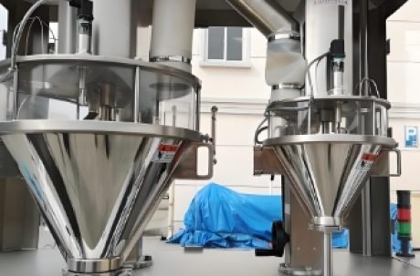 Powder filled containers moving on conveyor belt