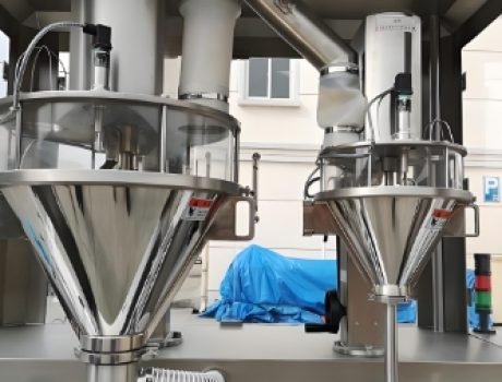 Powder filled containers moving on conveyor belt