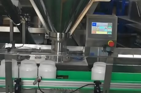 Powder filling machine dispensing product into plastic bottles