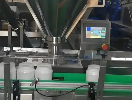 Powder filling machine dispensing product into plastic bottles