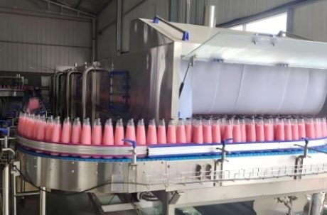 Bottles moving through high-speed rotary filling carousel