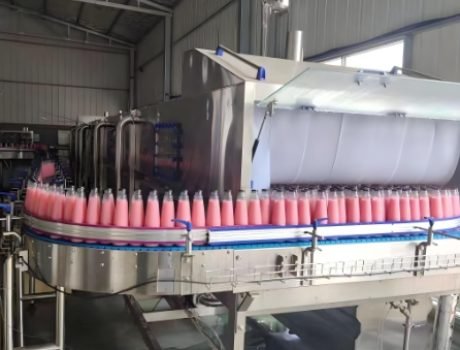 Bottles moving through high-speed rotary filling carousel