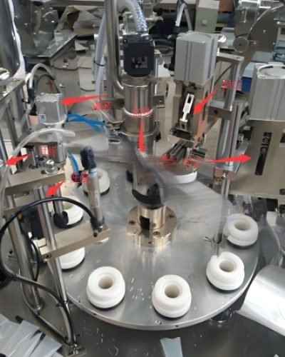 Filling machine dispensing product into tubes with precise automation.