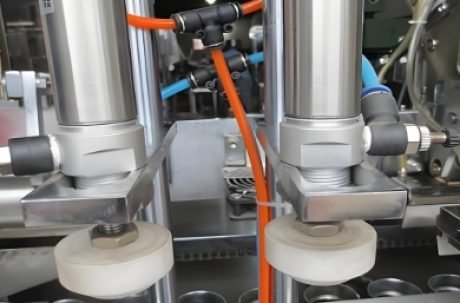 Automated system placing tubes in position for filling and sealing.