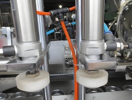 Automated system placing tubes in position for filling and sealing.