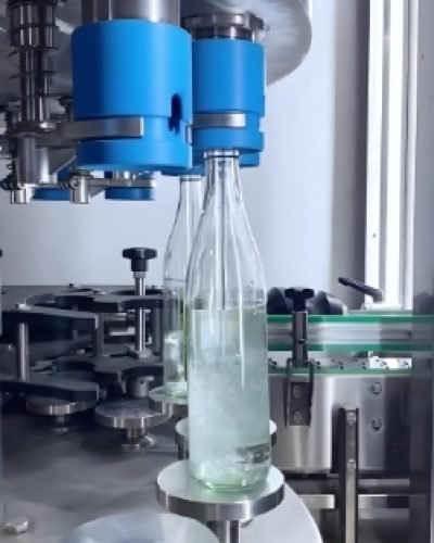 Automated beverage filling and capping machine filling bottles with precision.