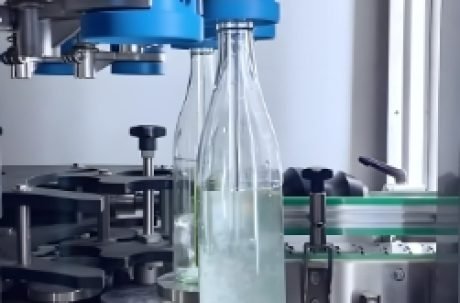 Automated beverage filling and capping machine filling bottles with precision.