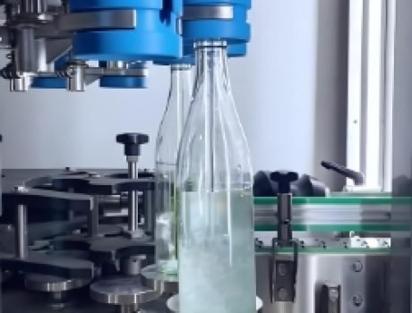 Automated beverage filling and capping machine filling bottles with precision.
