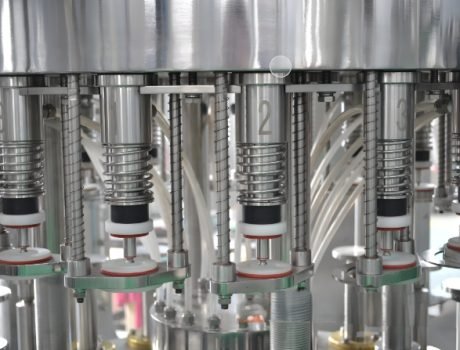 Bottles moving on a conveyor for filling and capping in an automated system.