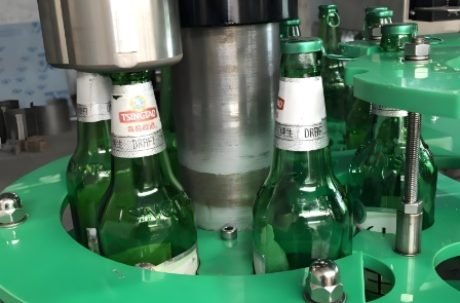 Bottle filling system applying caps and sealing bottles during production.