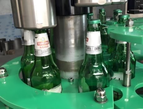 Bottle filling system applying caps and sealing bottles during production.