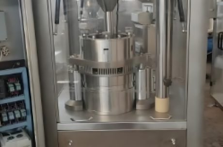 Capsule production machine sorting and filling orange capsules.