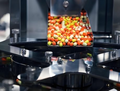 Capsules moving through a high-speed sorting and packaging system.