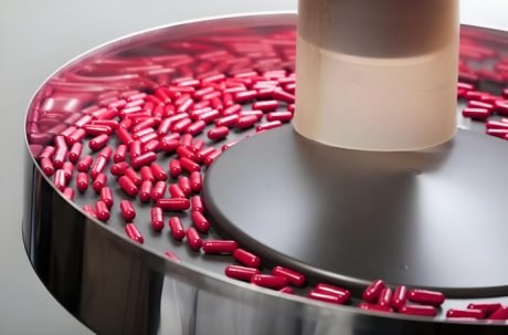 Pharmaceutical capsule production line with automated sorting and filling systems.