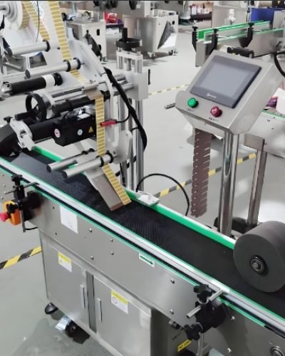 Conveyor system feeding bottles into an automated labeling machine for quick processing.