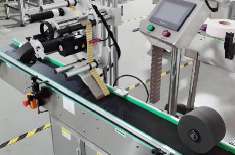 Conveyor system feeding bottles into an automated labeling machine for quick processing.
