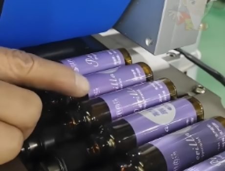 Automated labeling machine applying labels to containers on a conveyor belt