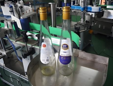 Bottles being labeled by a Labeling Machine on a production line, "Mango Juice" text visible.