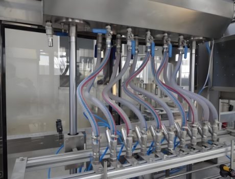 Automatic liquid filling machine with multiple nozzles, ready for bottling production.
